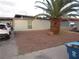 Modest single-story house with a desert-style front yard, featuring a large palm tree and gravel landscaping at 2409 Maroney Ave, Las Vegas, NV 89104