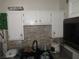 Functional kitchen sink area with white cabinets, a dark faucet, and a tiled backsplash at 2409 Maroney Ave, Las Vegas, NV 89104
