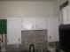Practical kitchen sink area with white cabinets and a contrasting tile backsplash at 2409 Maroney Ave, Las Vegas, NV 89104