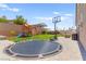 Well-maintained backyard featuring a trampoline, basketball hoop, play structure, and patio at 245 Hull St, Henderson, NV 89015