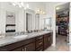 Bathroom with dual sinks, granite counters, a large mirror, and walk in closet at 245 Hull St, Henderson, NV 89015