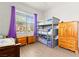 Cozy bedroom showcasing a triple bunk bed, natural light, and wood-look flooring at 245 Hull St, Henderson, NV 89015