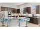Modern kitchen featuring dark wood cabinetry, granite countertops, stainless steel appliances and island seating at 245 Hull St, Henderson, NV 89015