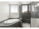 Modern main bathroom showcasing a soaking tub, separate shower with window, and granite countertops at 245 Hull St, Henderson, NV 89015
