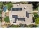 Aerial view of house featuring solar panels, skylights, tile roof, lush greenery, and a swimming pool at 2500 Wimbledon Dr, Las Vegas, NV 89107