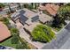 Home aerial view featuring a large driveway, lush greenery, solar panels, and a well-maintained tile roof at 2500 Wimbledon Dr, Las Vegas, NV 89107