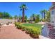Expansive backyard highlighting mature palm trees, a hot tub, and meticulously maintained landscaping at 2500 Wimbledon Dr, Las Vegas, NV 89107
