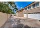 Home exterior featuring a spacious three-car garage, adjacent to private patio area at 2500 Wimbledon Dr, Las Vegas, NV 89107
