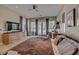 Well-lit main bedroom with large windows, TV, ceiling fan, and carpeted floors at 2500 Wimbledon Dr, Las Vegas, NV 89107