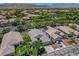 An aerial view of a single-story home with lush trees, solar panels, and mountain views from a desert neighborhood at 2687 Ivoryhill St, Las Vegas, NV 89135