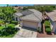 Aerial view showcasing a single-Gathering home with tile roof, two-car garage, and a landscaped front yard at 2687 Ivoryhill St, Las Vegas, NV 89135