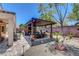 Spacious backyard featuring a covered patio with an outdoor kitchen, brick wall, and inviting seating area at 2687 Ivoryhill St, Las Vegas, NV 89135