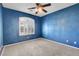 Bedroom with blue walls, carpeted floor, ceiling fan, and a window at 2687 Ivoryhill St, Las Vegas, NV 89135