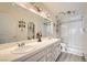 Bright bathroom featuring double sinks, a large mirror, and a glass-enclosed shower with tile surround at 2725 S Nellis Blvd # 2084, Las Vegas, NV 89121