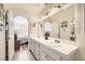 Bright bathroom featuring double sinks, a large mirror, white cabinets and views to the bedroom at 2725 S Nellis Blvd # 2084, Las Vegas, NV 89121