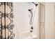 Close-up of tile shower with black shower head and patterned shower curtain at 2725 S Nellis Blvd # 2084, Las Vegas, NV 89121
