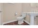 Bathroom features a pedestal sink, toilet, and hardwood flooring at 2864 Kinknockie Way, Henderson, NV 89044