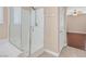 Bright bathroom with a glass-enclosed shower, tile flooring, and a linen closet at 2864 Kinknockie Way, Henderson, NV 89044