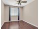 Simple bedroom with hardwood floors, a ceiling fan, and a large window at 2864 Kinknockie Way, Henderson, NV 89044
