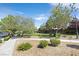 Landscaped community with green spaces, sidewalks, trees, and manicured shrubs and flowering bushes at 2864 Kinknockie Way, Henderson, NV 89044
