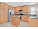 Kitchen features stainless steel appliances, central island, oak cabinets, and tile flooring at 2864 Kinknockie Way, Henderson, NV 89044