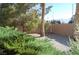 Gravel filled backyard with a chain link fence and mature landscaping at 30 Diamond Bar Rd, Pahrump, NV 89048