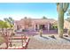 View of the backyard and patio, with desert landscaping, mature trees, and a vibrant flowering tree at 3013 Sungold Dr, Las Vegas, NV 89134