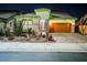 Single-Gathering home with desert landscaping, brick driveway, and festive green holiday lights at 3096 Beaux Art Ave, Henderson, NV 89044