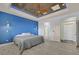 This main bedroom boasts a blue accent wall, light hardwood floors, and a unique tray ceiling with accent lighting at 3096 Beaux Art Ave, Henderson, NV 89044
