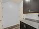 Pantry with granite countertops, dark cabinets, light grey walls, and striped floors near a white door at 3096 Beaux Art Ave, Henderson, NV 89044