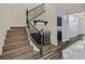 Elegant staircase with wooden steps, black wrought iron railing, and wet bar at 3096 Beaux Art Ave, Henderson, NV 89044