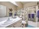 Charming bathroom featuring tile countertops, decorative mirror, and a shower-tub with modern fixtures at 344 Golden Shore Dr, Las Vegas, NV 89123