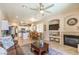 Open-concept living room featuring a fireplace, a view to the kitchen, and seating with a brown sofa at 344 Golden Shore Dr, Las Vegas, NV 89123