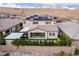View of the back of a two-story home featuring solar panels, outdoor kitchen and landscaped backyard in a residential area at 3929 Reyes Ave, Las Vegas, NV 89141
