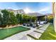 Lush backyard featuring a putting green, outdoor lounge, and manicured landscaping for leisure and relaxation at 3929 Reyes Ave, Las Vegas, NV 89141