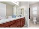 Bathroom featuring double sinks with wooden cabinets, a large mirror, and modern fixtures at 3929 Reyes Ave, Las Vegas, NV 89141