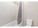Clean bathroom featuring a white toilet, and a bathtub with grey shower curtain at 3929 Reyes Ave, Las Vegas, NV 89141