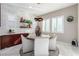 Bright dining area featuring a modern light fixture, white chairs, and decorative shelving at 3929 Reyes Ave, Las Vegas, NV 89141