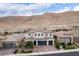Charming front exterior featuring desert landscaping and a three-car garage, set against a mountain backdrop at 3929 Reyes Ave, Las Vegas, NV 89141