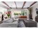 Open living room showcasing a gray sectional, a view of the outdoor patio, and wood beam ceilings at 3929 Reyes Ave, Las Vegas, NV 89141