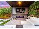 Stylish outdoor living space with a cozy fireplace, large screen television, and comfortable seating area at 3929 Reyes Ave, Las Vegas, NV 89141