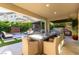 Lovely outdoor patio with ample seating, outdoor kitchen, and serene views of the backyard at 3929 Reyes Ave, Las Vegas, NV 89141