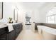 The luxurious bathroom features a soaking tub, double vanity, and arched window for natural light and a peaceful retreat at 4016 Tyler William Ln, Las Vegas, NV 89130