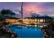 Backyard featuring a pristine pool with a rock border and a covered patio at sunset at 4016 Tyler William Ln, Las Vegas, NV 89130