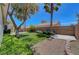 Landscaped backyard featuring green grass and trees with brick perimeter at 4197 Bottiglia Ave, Las Vegas, NV 89141