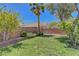 Lush backyard featuring green grass, mature trees, and decorative brick edging at 4197 Bottiglia Ave, Las Vegas, NV 89141