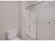 Bathroom featuring a toilet and tub with a shower head and glass doors at 4197 Bottiglia Ave, Las Vegas, NV 89141