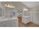 Bright bathroom featuring dual sinks, white cabinets, tile floors, and walk-in shower at 4197 Bottiglia Ave, Las Vegas, NV 89141