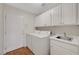 Well-equipped laundry room with a washer, dryer, sink, and ample storage cabinets at 4197 Bottiglia Ave, Las Vegas, NV 89141