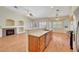 Open concept living room with kitchen and fireplace, laminate wood flooring and ample lighting at 4197 Bottiglia Ave, Las Vegas, NV 89141